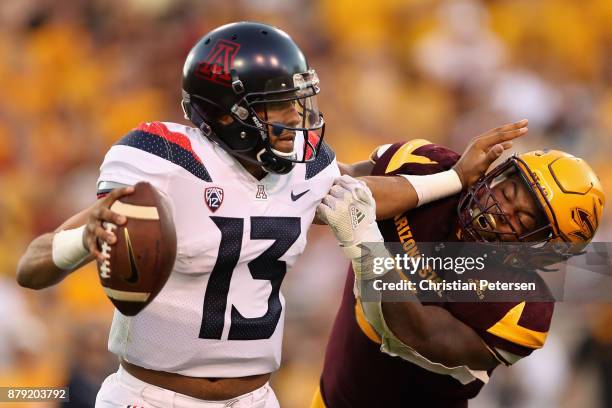 Quarterback Brandon Dawkins of the Arizona Wildcats is sacked by linebacker Christian Sam of the Arizona State Sun Devils during the second half of...