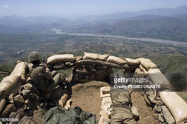Pakistani soldiers stand guard on top of a mountain overlooking the Swat valley at Banai Baba Ziarat area in northwest Pakistan on May 22, 2009. The...