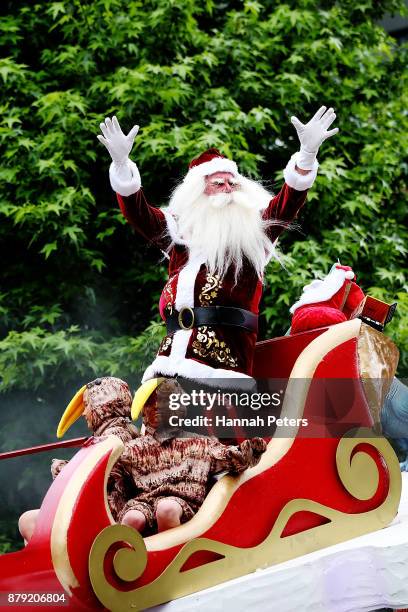 Santa waves to the crowds during the annual Farmers Santa Parade on November 26, 2017 in Auckland, New Zealand. The Farmers Santa Parade has brought...