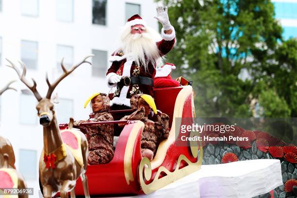 Santa waves to the crowds during the annual Farmers Santa Parade on November 26, 2017 in Auckland, New Zealand. The Farmers Santa Parade has brought...