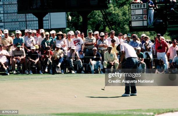 Masters Champion Sandy Lyle watches his putt on the ninth green in front of a large gallery during the 1988 Masters Tournament at Augusta National...