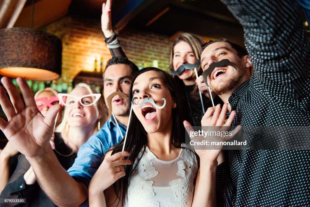 New Years Eve in a bar between group of coworkers and colleagues doing photo booths
