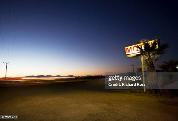 motel sign along highway at night - motel stock-fotos und bilder