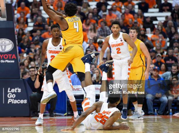 Tyus Battle of the Syracuse Orange lands on the court after falling over Tre'Shaun Fletcher of the Toledo Rockets while attempting to block a shot...