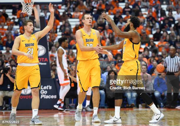Dylan Alderson and Luke Knapke of the Toledo Rockets greet teammate Tre'Shaun Fletcher after a made basket against the Syracuse Orange during the...