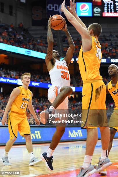 Geno Thorpe of the Syracuse Orange drives to the basket for a shot against the defense of Luke Knapke of the Toledo Rockets during the second half at...