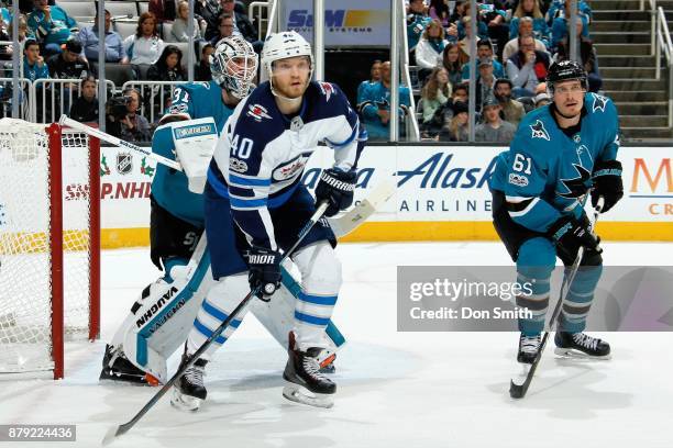 Martin Jones and Justin Braun of the San Jose Sharks defend Joel Armia of the Winnipeg Jets at SAP Center on November 25, 2017 in San Jose,...