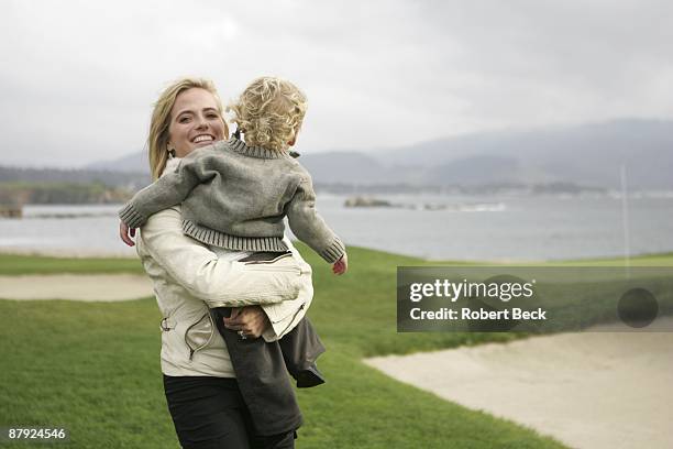 Pebble Beach Pro-Am: Amy Mickelson, wife of Phil Mickelson holding son Evan during Sunday play. Pebble Beach, CA 2/13/2005 CREDIT: Robert Beck