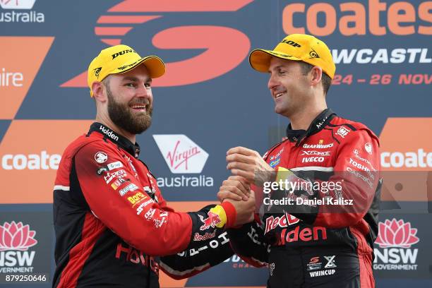 2nd place Shane Van Gisbergen driver of the Red Bull Holden Racing Team Holden Commodore VF celebrates with 1st place Jamie Whincup driver of the Red...