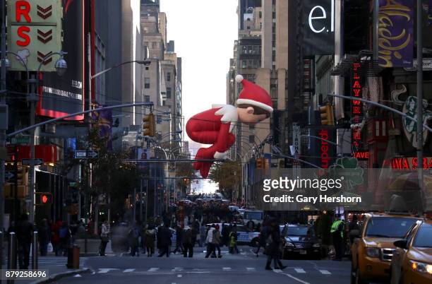 The Elf on a Shelf balloon floats down 6th Avenue as it crosses 49th Street during the annual Thanksgiving Day Parade on November 23, 2017 in New...