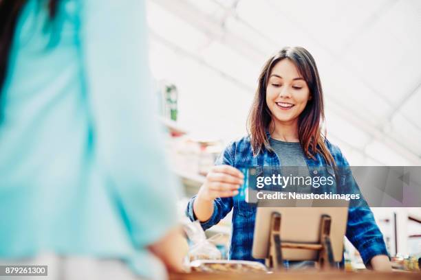 eingang der zahlung durch kreditkarte vom kunden glücklich deli-besitzer - neustockimages stock-fotos und bilder