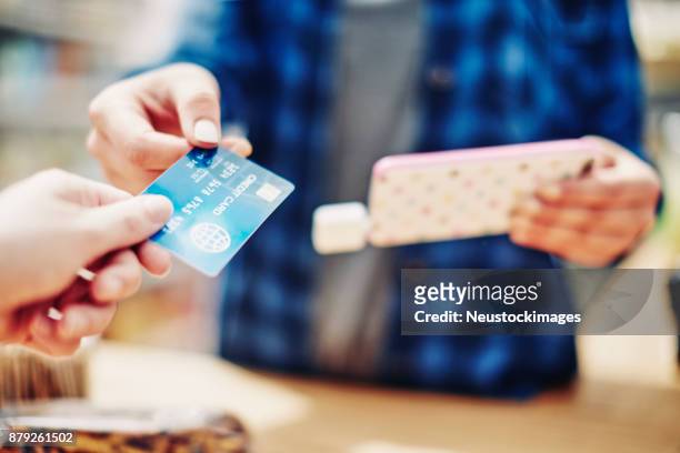 verkäuferin kreditkarte erhalten kunden smartphone mit gedrückter - neustockimages stock-fotos und bilder