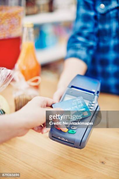 deli-besitzer erhalten kunden zahlung per kreditkarte - neustockimages stock-fotos und bilder
