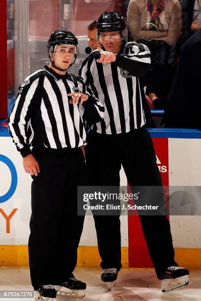 Linesmen James Tobias and Pierre Racicot chat before overtime starts between the Toronto Maple Leafs and Florida Panthers at the BB&T Center on...