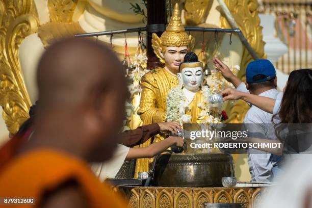People offer water to a statute of Buddha in the courtyard of the Shwedagon Pagoda in Yangon on November 26, 2017. Pope Francis arrives in Myanmar on...