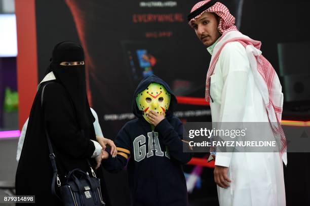 Saudi family accompanies their child, who is wearing a Jason Voorhees hockey mask from the Friday the 13th horror film series, as they attend the...