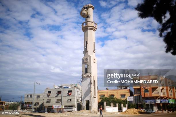 Palestinian boy walks past the damaged minaret of a mosque in Beit Hanun in the northern Gaza Strip on November 24 which was damaged during the...