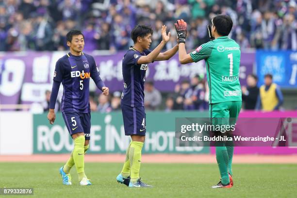 Azuhiko Chiba, Hiroki Mizumoto and Takuto Hayashi of Sanfrecce Hiroshima celebrate their 2-1 victory and avoid the relegation to the J2 after the...