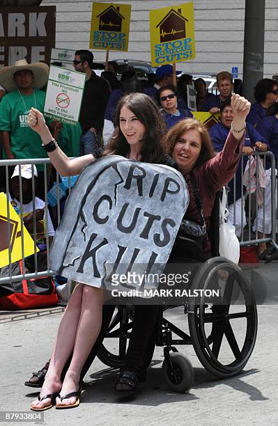 Julie Williams and her daughter Britney join healthcare workers as they protest against proposed cuts to the public health system during a...