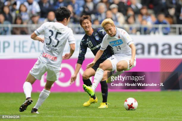 Akito Fukumori of Consadole Sapporo and Shun Nagasawa of Gamba Osaka compete for the ball during the J.League J1 match between Gamba Osaka and...