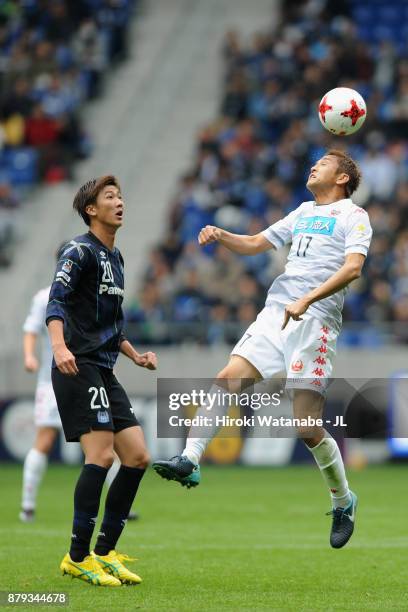 Junichi Inamoto of Consadole Sapporo and Shun Nagasawa of Gamba Osaka compete for the ball during the J.League J1 match between Gamba Osaka and...