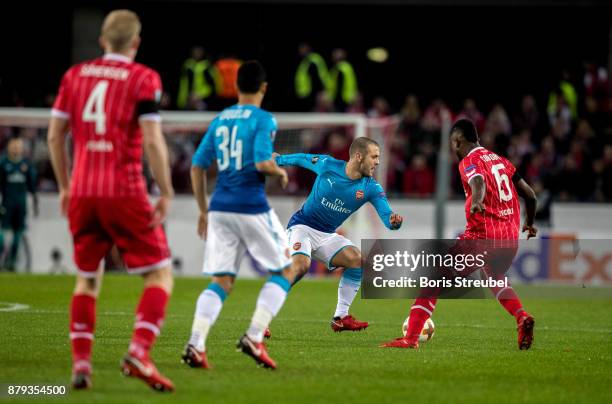 Jack Wilshere of Arsenal is challenged by Jhon Cordoba of 1.FC Koeln during the UEFA Europa League group H match between 1. FC Koeln and Arsenal FC...