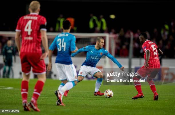 Jack Wilshere of Arsenal is challenged by Jhon Cordoba of 1.FC Koeln during the UEFA Europa League group H match between 1. FC Koeln and Arsenal FC...