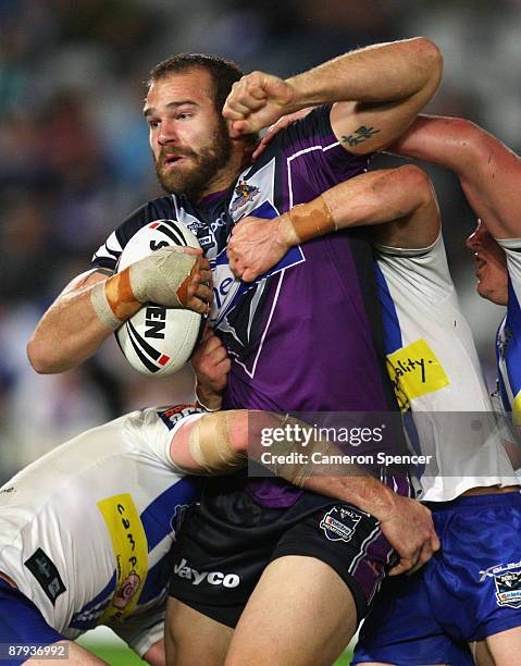 Scott Anderson of the Storm is tackled during the NRL round 11 match between the Bulldogs and the Melbourne Storm at Bluetongue Stadium on May 23,...