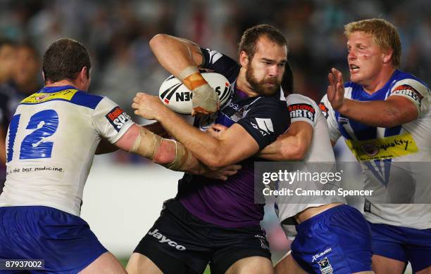 Scott Anderson of the Storm is tackled during the NRL round 11 match between the Bulldogs and the Melbourne Storm at Bluetongue Stadium on May 23,...