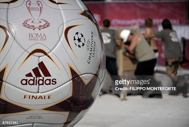 Workers pass by a giant UEFA Champions League soccer ball at the Champions Village in Rome's Colle Oppio on May 23, 2009 in Rome. The Champions...