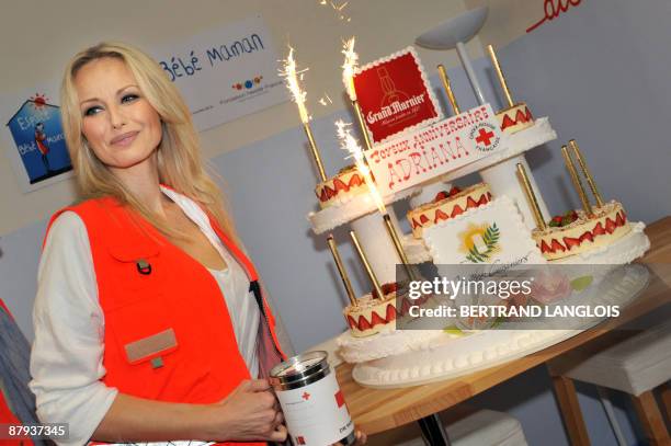 French Red Cross goodwill ambassador and top-model Adriana Karembeu poses next to a birthday cake during the launch of Red Cross 2009 national...