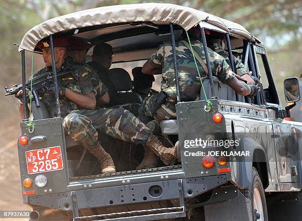 Sri Lankan soldiers escort the convoy of United Nations Secretary-General Ban Ki-moon during his visit to Menik Farm refugee camp in Cheddikulam on...