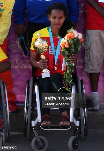First place winner in women's Great Ethiopian Run disabled Ethiopian athlete Moris Getenet holds flowers and a trophy at Adwa Square in Addis Ababa,...