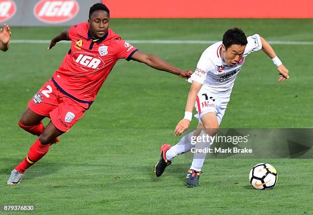 Jumpei Kusukami of West Sydney Wanderers gets away from Mark Ochieng of Adelaide United during the round eight A-League match between Adelaide United...
