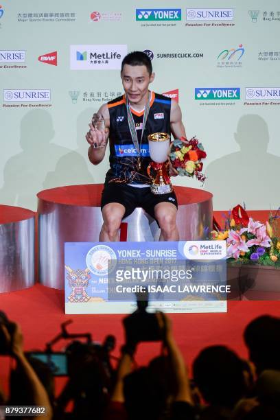 Malaysia's Lee Chong Wei poses for the media after winning the men's singles final against China's Chen Long at the Hong Kong Open badminton...