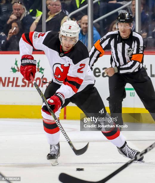 John Moore of the New Jersey Devils plays the puck down the ice during first period action against the Winnipeg Jets at the Bell MTS Place on...