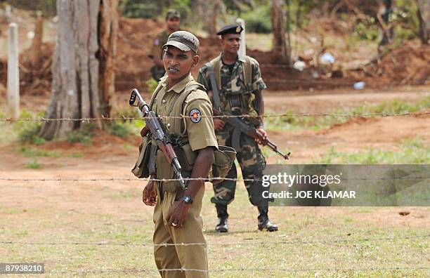 Sri Lankan soldiers stand guard during United Nations Secretary-General Ban Ki-moon's visit to Menik Farm refugee camp in Cheddikulam on May 23,...