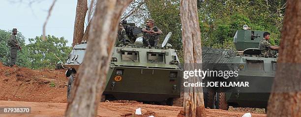 Sri Lankan soldiers stand guard on armoured personnel carriers during United Nations Secretary-General Ban Ki-moon's visit to Menik Farm refugee camp...