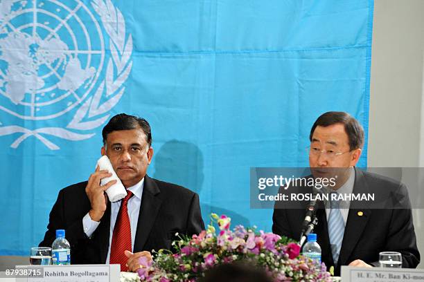 Sri Lankan Minister of Foreign Affairs Rohitha Bogollagama wipes his face as United Nations Secretary General Ban Ki-moon anwers questions from the...