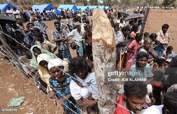 Internally displaced Sri Lankan people look on during a visit by United Nations Secretary-General Ban Ki-moon at Menik Farm refugee camp in...