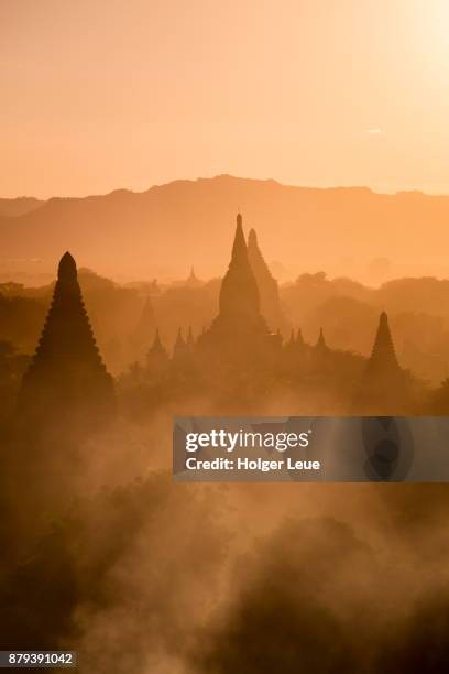 silhouette of pagodas and stupas seen from shwesandaw pagoda at sunset, bagan, mandalay, myanmar - bagan photos et images de collection