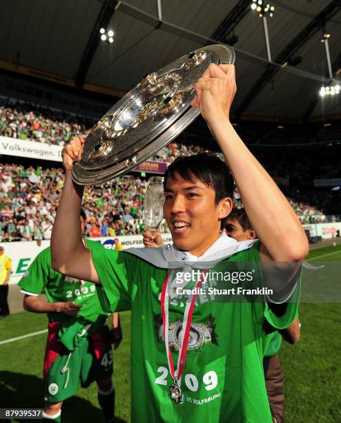 Makoto Hasebe of Wolfsburg lifts the German Championship trophy after the Bundesliga match between VfL Wolfsburg and Werder Bremen at the Volkswagen...