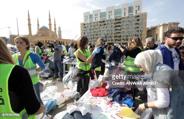 Volunteers sort through aid, consisting of winter clothing, blankets, heaters and other necessities, in the capital Beirut's Martyrs Square on...