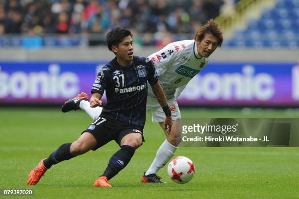 Akito Takagi of Gamba Osaka and Shingo Hyodo of Consadole Sapporo compete for the ball during the J.League J1 match between Gamba Osaka and Consadole...
