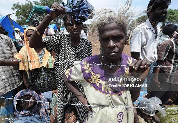 Internally displaced Sri Lankan people wait behind barbed wire during a visit by United Nations Secretary-General Ban Ki-moon at Menik Farm refugee...