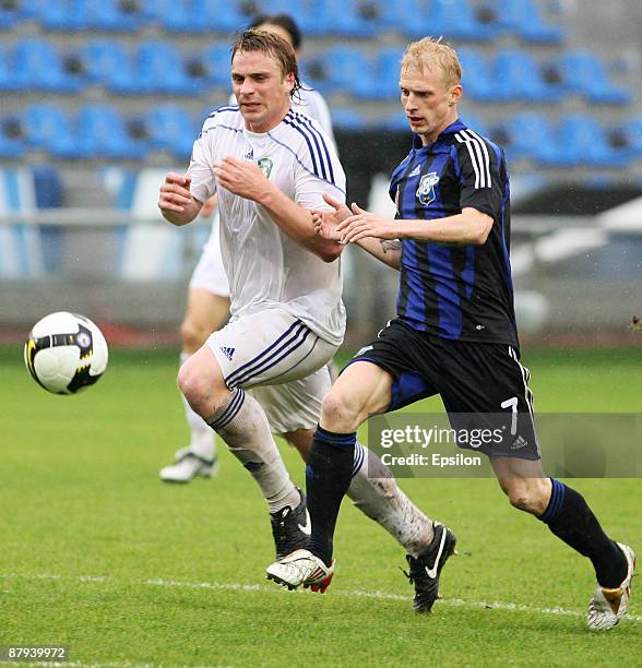 Petr Nemov of FC Saturn Moscow Oblast battles for the ball with Sergey Kornilenko of FC Tom', Tomsk during the Russian Football League Championship...