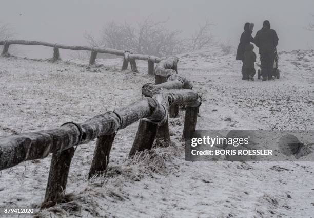 Members of a family make their way through the snow as they go for a walk on the Feldberg mountain in the Taunus region near Schmitten, western...