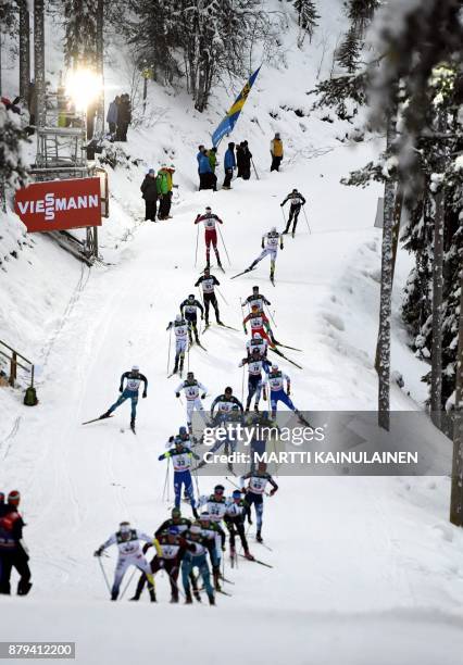 Skiers compete during the Mens' cross country skiing 15km free style pursuit event at the FIS World Cup Ruka Nordic 2017 in Ruka, Kuusamo in northern...