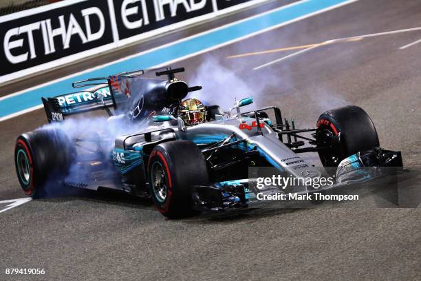 Second place finisher Lewis Hamilton of Great Britain and Mercedes GP celebrates with donuts on track during the Abu Dhabi Formula One Grand Prix at...