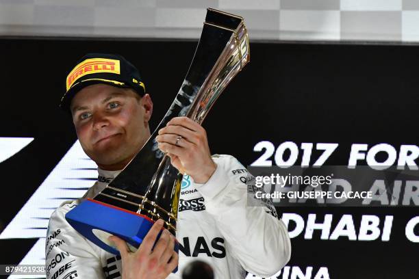 Mercedes' Finnish driver Valtteri Bottas celebrates on the podium at the end of the Abu Dhabi Formula One Grand Prix at the Yas Marina circuit on...